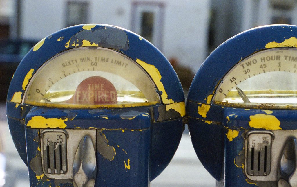 Old blue parking meters reading "expired" procrastination