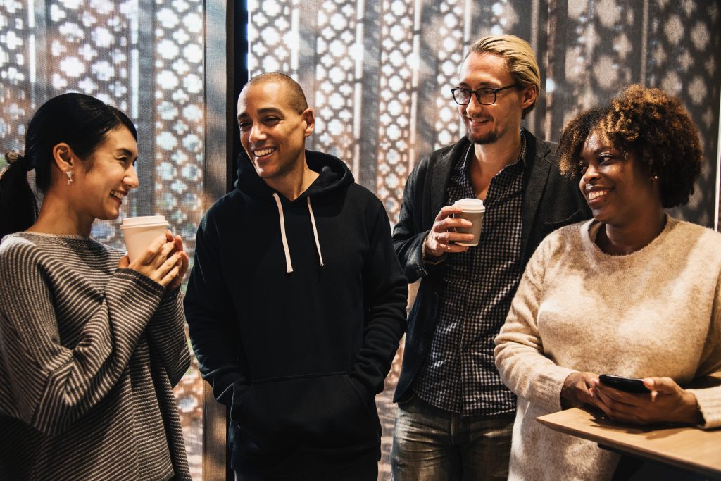 4 adults socializing over coffee