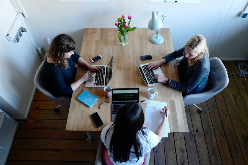 3 women working on laptops at a table