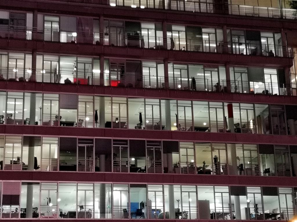 Exterior of office building lit up from inside.